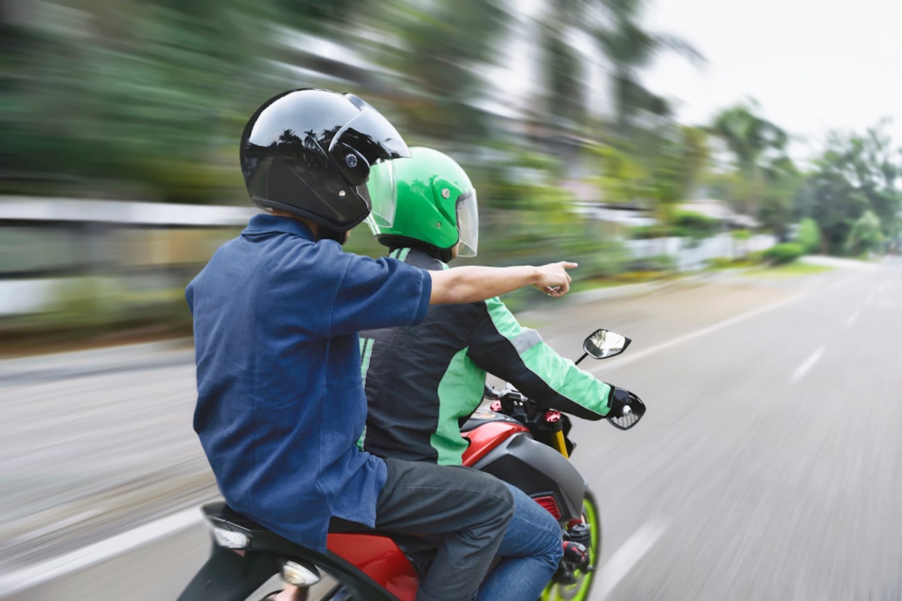 motorcycle passenger pointing ahead