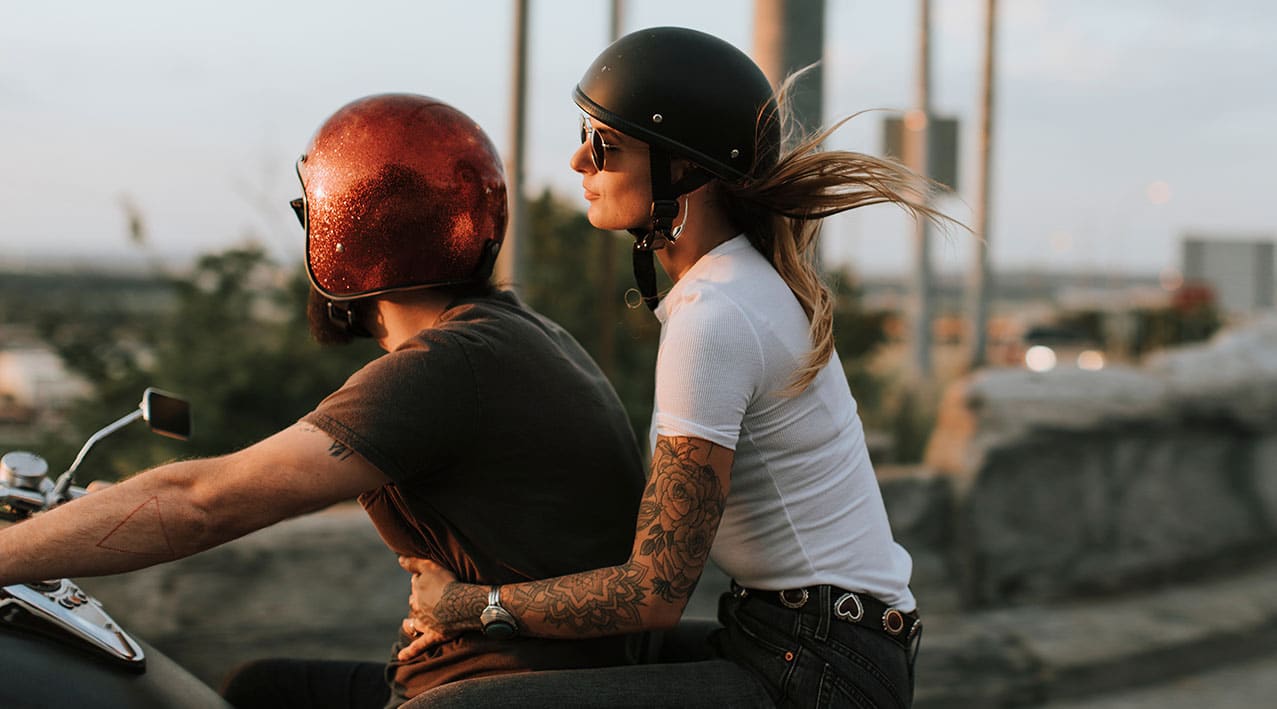 biker couple riding during sunset