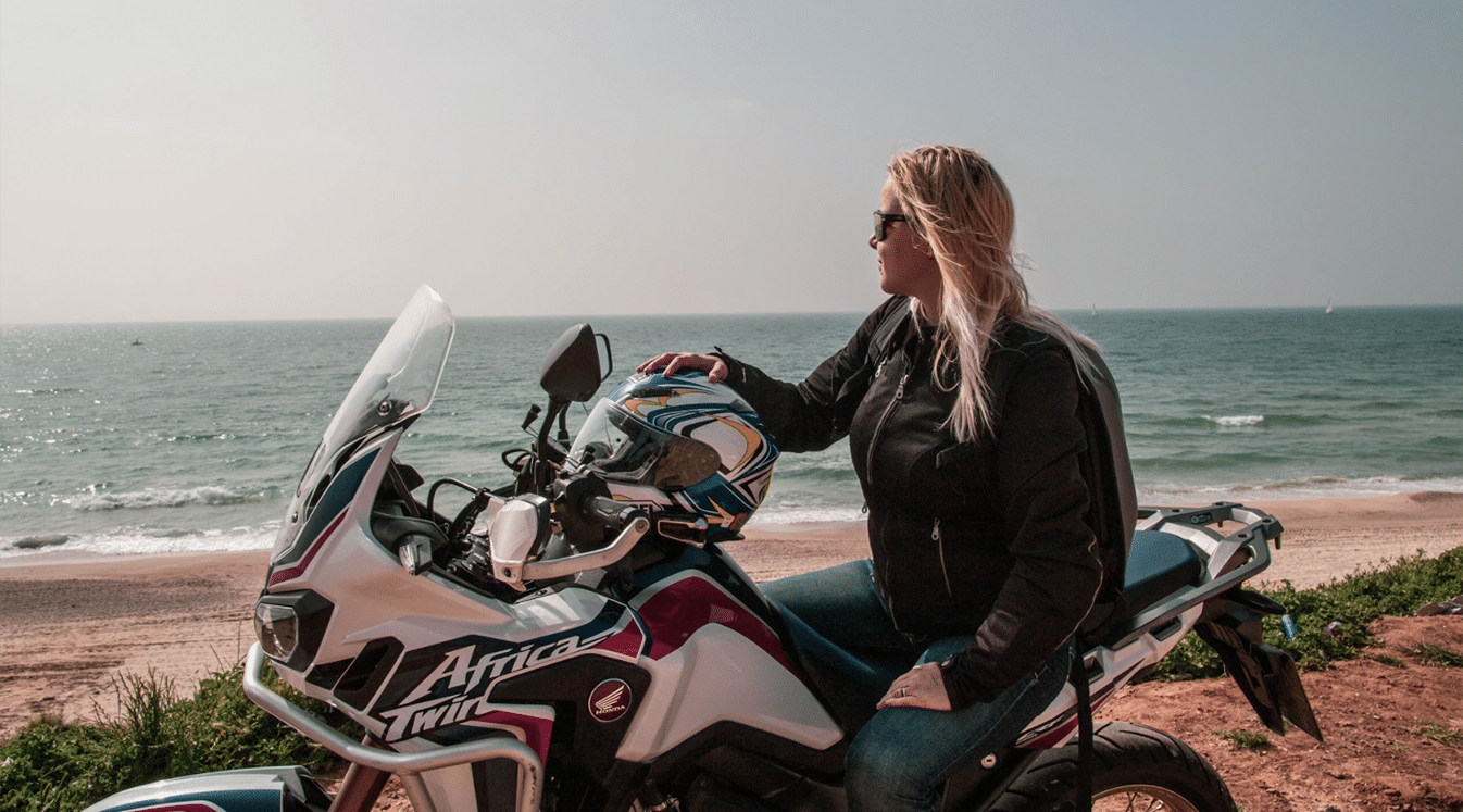 woman riding motorcycle on coastline