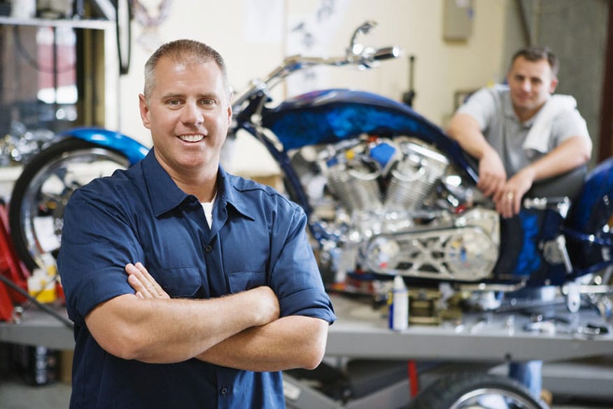 smiling mechanic motorcycle repair shop