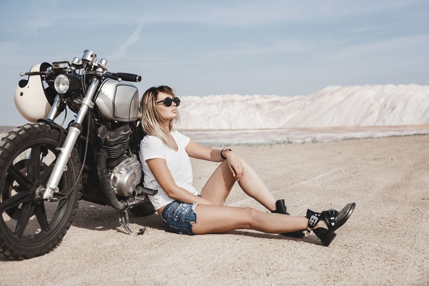 woman sitting beside motorcycle